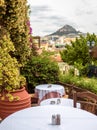 Cozy street cafe with flowers and plants in Plaka district, Athens, Greece. Plaka is tourist attraction of old Athens Royalty Free Stock Photo