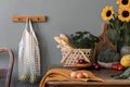 Cozy and stylish composition of creative dining room with mock up poter frame, wooden console, sunflowers and personal accessories