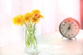 Cozy summer still life with flowers of and alarm clock on the table. At home. Rustic style, Lazy weekend. Haze vintage filter Royalty Free Stock Photo