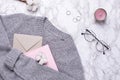 Cozy sweater with envelope , pink notebook and rings on marble background Royalty Free Stock Photo