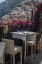 A cozy table in a cafe with a white tablecloth with a beautiful view of the city of Positano in Italy Royalty Free Stock Photo