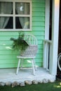 Cozy terrace with wooden old chair and basket with flowers. Decorations in summer patio for relax. Stylish summer decor on front p Royalty Free Stock Photo