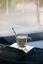 Cozy winter autumn still life: cup of hot tea, warm plaid and opened book on windowsill. Minimal unplug calmness relax concept,