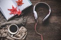 Cozy winter background, cup of hot coffee with marshmallow and headphone music and book note,