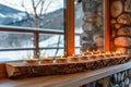 Cozy Winter Candle Display on Wooden Shelf with Snowy Landscape View Royalty Free Stock Photo