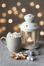 Cozy winter holiday background with gingerbread cookies on table, candles and a cup of coffee with marshmallows