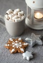 Cozy winter holiday background with gingerbread cookies on table, candles and a cup of coffee with marshmallows Royalty Free Stock Photo