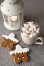 Cozy winter holiday coffee with cute stars gingerbread biscuit cookies on table, candles and grey cup with marshmallows Royalty Free Stock Photo