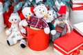 Cozy winter holidays background. Funny toy snowmen and presents waiting for christmas under decorated fir tree. Joyful Royalty Free Stock Photo