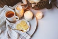 Cozy winter morning at home. Hot tea with lemon, candles, knitted sweaters in basket and modern metallic interior details. Still l Royalty Free Stock Photo