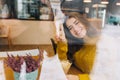 Cozy winter portrait of young smiled woman in window comfortable cafe in big city. Chilling inside in cold winter