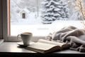 Cozy winter still life cup of hot coffee and opened book with warm plaid on vintage windowsill of cottage against snow landscape