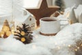 Cozy winter still life. Stylish cup of tea with modern christmas decoration, pine cone, wooden star and tree, golden light on soft Royalty Free Stock Photo