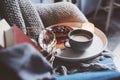 Cozy winter weekend at home. Morning with coffee or cocoa, berry pie, books, warm knitted blanket and nordic style chair. Hygge co Royalty Free Stock Photo