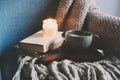 Cozy winter weekend at home. Morning with coffee or cocoa, books, warm knitted blanket and nordic style chair. Hygge concept. Royalty Free Stock Photo