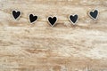 Cozy wooden background, with 5 black hearts fastened between them with a hemp rope, love concept, for Valentine`s Day,