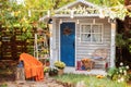 Cozy wooden house porch with chair, blanket, potted chrysanthemums and pumpkins. Decor outdoor of autumn yard. Facade House decora