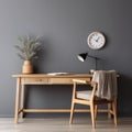 Cozy workplace with wooden writing desk and chair near grey wall. Interior design of modern Scandinavian home office