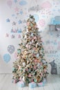 Cozy Xmas decor children room. Christmas tree decorated with toys, balls and lights garlands in home. Xmas interior of living room Royalty Free Stock Photo