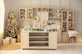 Cozy Xmas kitchen interior with furniture. Stylish cuisine with decorated Christmas tree and gifts.