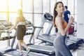 Young attractive girl in the gym drinking water on the background of treadmills Royalty Free Stock Photo