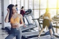 Young attractive girl in the gym drinking water on the background of treadmills Royalty Free Stock Photo