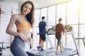 Young attractive girl in the gym drinking water on the background of treadmills Royalty Free Stock Photo