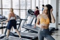 Young attractive girl in the gym drinking water on the background of treadmills Royalty Free Stock Photo