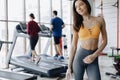 Young attractive girl in the gym drinking water on the background of treadmills Royalty Free Stock Photo