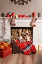 Cozyness and home comfort. Decorated fireplace with firewood. Winter holidays room interior, Christmas atmosphere.