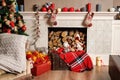 Cozyness and home comfort. Decorated fireplace with firewood. Winter holidays room interior, Christmas atmosphere.