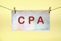 CPA Certified Public Accountant lettering on colored paper hanging in front of a yellow background with a rope and clothespins Royalty Free Stock Photo