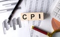 CPI text on wooden block on graph background with pen and magnifier Royalty Free Stock Photo