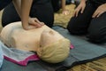 CPR First Aid Training with CPR dummy in the class. Demonstrating chest compressions concept Royalty Free Stock Photo