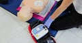 CPR training medical procedure workshop. Demonstrating chest compressions and use of AED automatic defibrillator on CPR Royalty Free Stock Photo