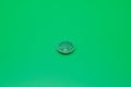 CR2035 button cell battery on a green background Royalty Free Stock Photo