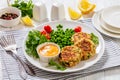 crab cakes with sauce, green peas, tomatoes