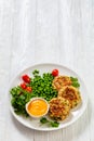 crab cakes with sauce, green peas, tomatoes