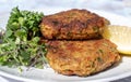 Crab cakes on the white plate with lemon and microgreens Royalty Free Stock Photo