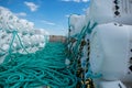 Crab catching cages stacked and ready for next use, teal lines attached to white cages, creative way to use plastic