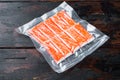 Crab stick surimi vacuum pack, on dark wooden background