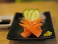 Crab sticks in a black dish placed on a table. Japanese foods