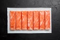 Crab sticks or imitation crab meat on black table Royalty Free Stock Photo