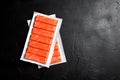 Crab sticks or imitation crab meat on black table top view Royalty Free Stock Photo