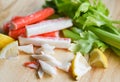 Crab sticks with lemon and fresh Celery vegetable on wooden plate Royalty Free Stock Photo