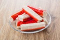 Crab sticks in transparent saucer on table