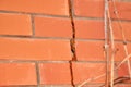 Crack in the brick wall of the house with the remnants of the mounting foam. The complex problem of the destruction of Royalty Free Stock Photo