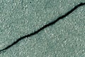 Crack on cyan asphalt surface. Royalty Free Stock Photo