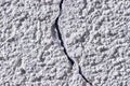 Crack in the gray concrete plastered wall. Quality background with rough texture for design Royalty Free Stock Photo