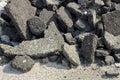 Cracked asphalt pieces after demolition of a road surface in a construction site for renovation ready to be recycled